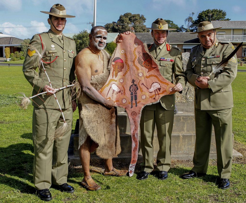Sergeant John Angel-Hands with the Four Direction Stick presented to him by the Ramindjeri people, Uncle Karno Walker and Chief of Army Lieutenant General David Morrison, AO with the kangaroo skin warrior's cloak, and Warrant Officer Class One Colin Watego with the Eagle Feather